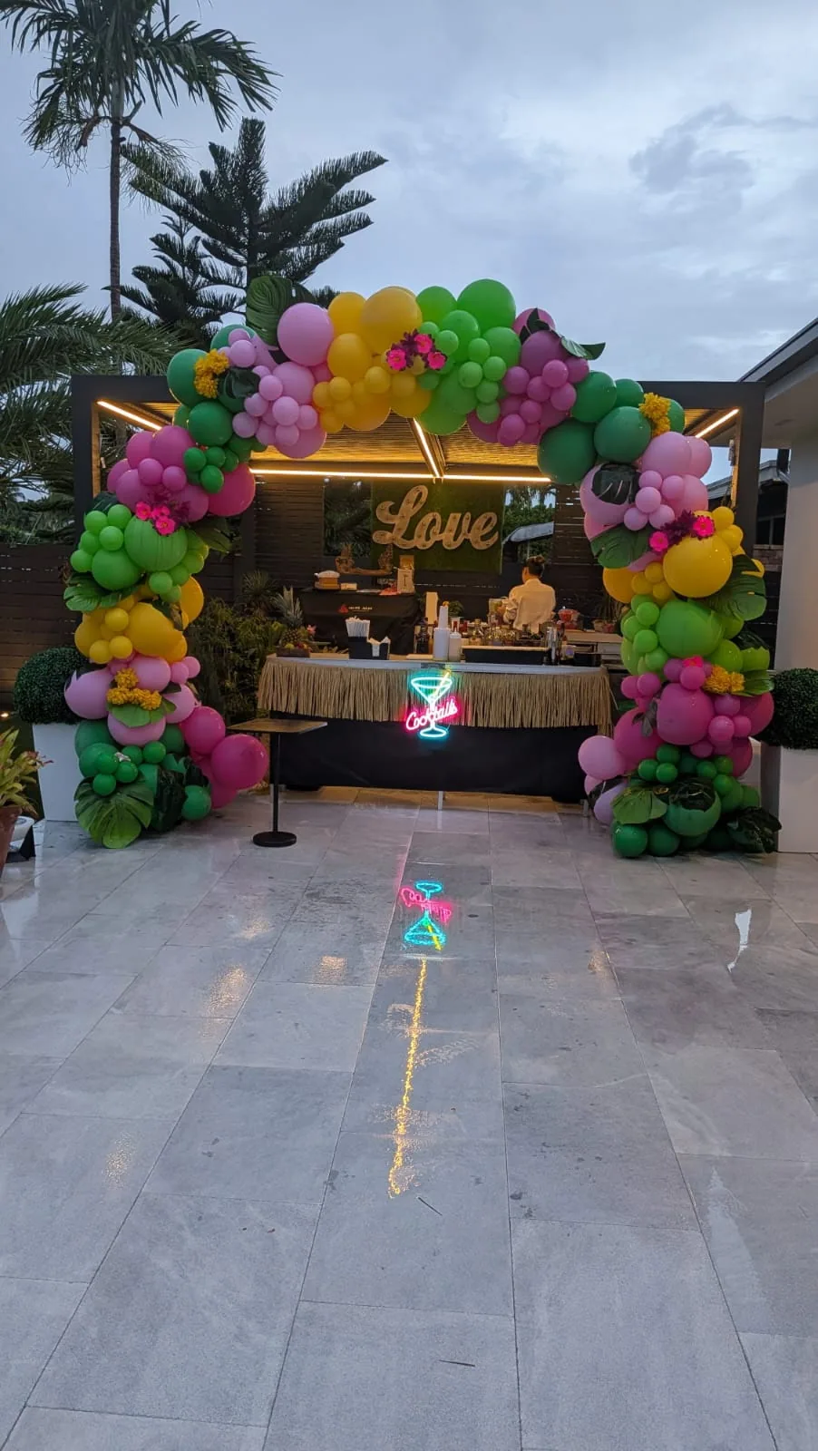 Tipsy Tides tropical mobile bar beneath a balloon arch